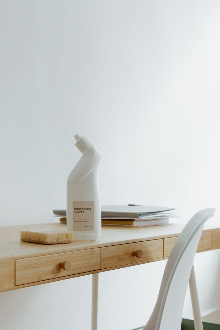 who-we-are A clean and organized home office desk with a cleaner bottle and sponge, emphasizing simplicity and functionality.